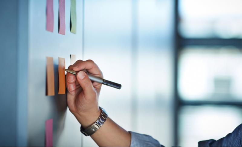 Person strategising on sticky notes