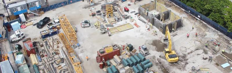 Construction site with heavy machinery and workers building a structure