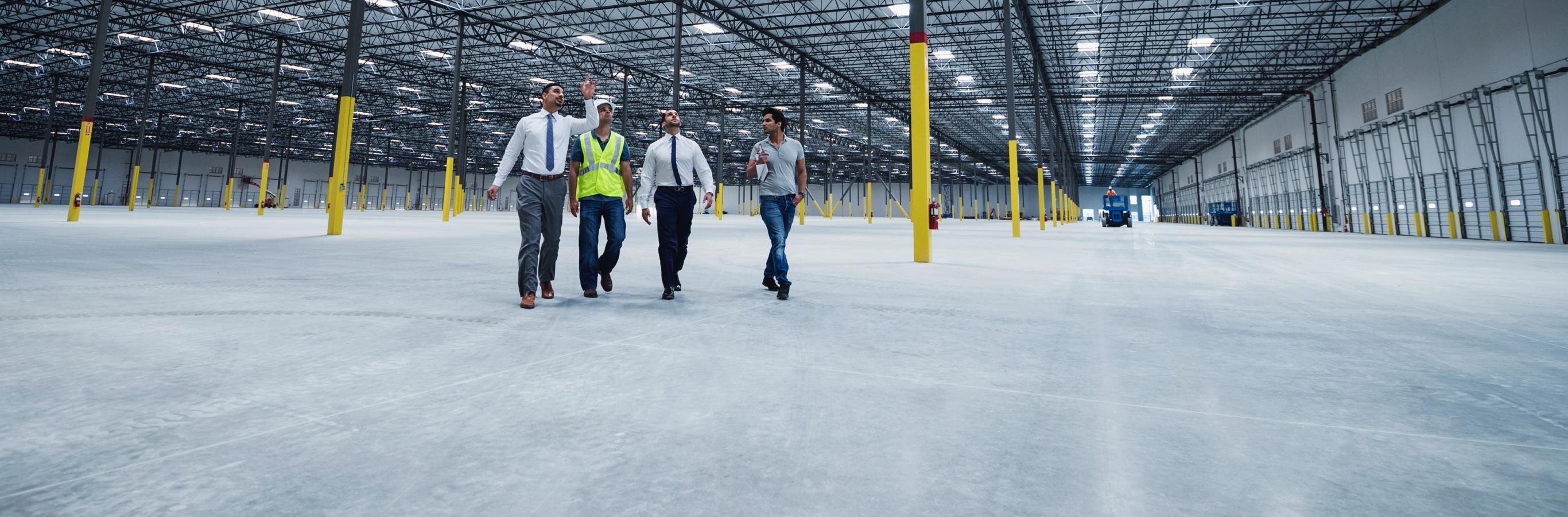 Investors walking through and inspecting an empty warehouse